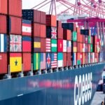 Navire cargo avec conteneurs et drapeaux nationaux.