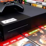 Consoles Xbox et manettes avec étiquettes de prix.