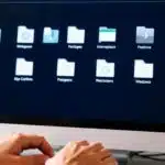 Dossiers organisés, écran d'ordinateur, mains tapant, espace libéré.