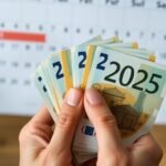 Main tenant des billets près d'un calendrier