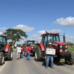 Tracteurs bloquant une route, agriculteurs en protestation.