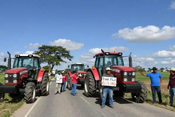 Tracteurs bloquant une route, agriculteurs en protestation.