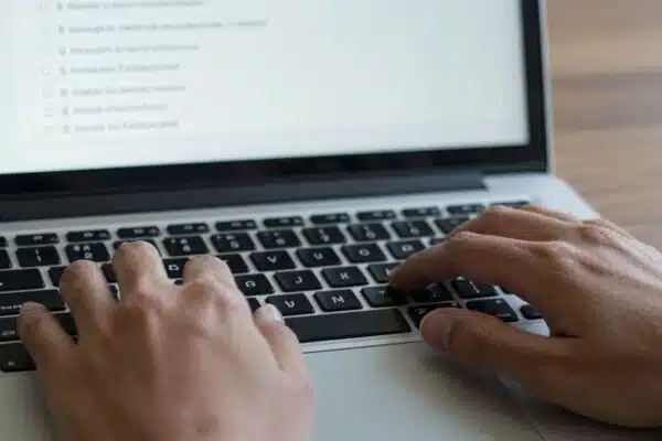 Mains tapant sur un clavier d'ordinateur portable dans un forum.